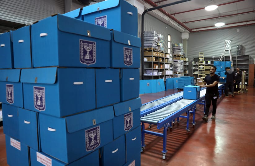 People sort ballot boxes as part of preparations for the upcoming Israeli election, during a briefing for members of the media at the Israel Central Election Committee Logistics Center in Shoham, Israel March 6, 2019 (photo credit: AMMAR AWAD/REUTERS)