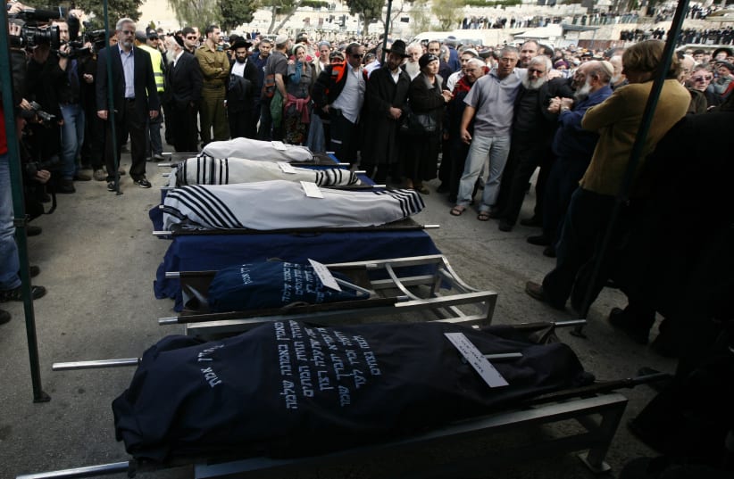 Mourners stand around the bodies of Ehud Fogel, 36, his wife Ruth, 35, and their children 11-year-old Yoav, 4-year-old Elad, and 3-month-old Hadas during their funeral in Jerusalem March 13th, 2011 (photo credit: BAZ RATNER/REUTERS)