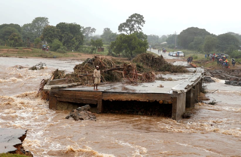 A man looks at a washed away bridge along Umvumvu river following Cyclone Ida (photo credit: PHILIMON BULAWAYO)