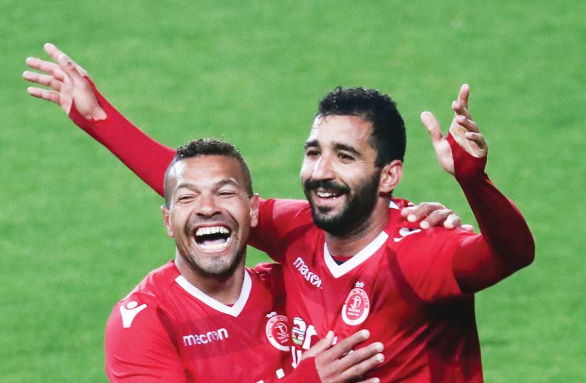 HAPOEL TEL AVIV defender Idan Cohen (right) celebrates with teammate Claudemir after scoring his team’s fifth goal in the 84th minute of the Reds’ 5-1 rout of Ashdod SC in Israel Premier League Relegation Playoffs action (photo credit: DANNY MARON)