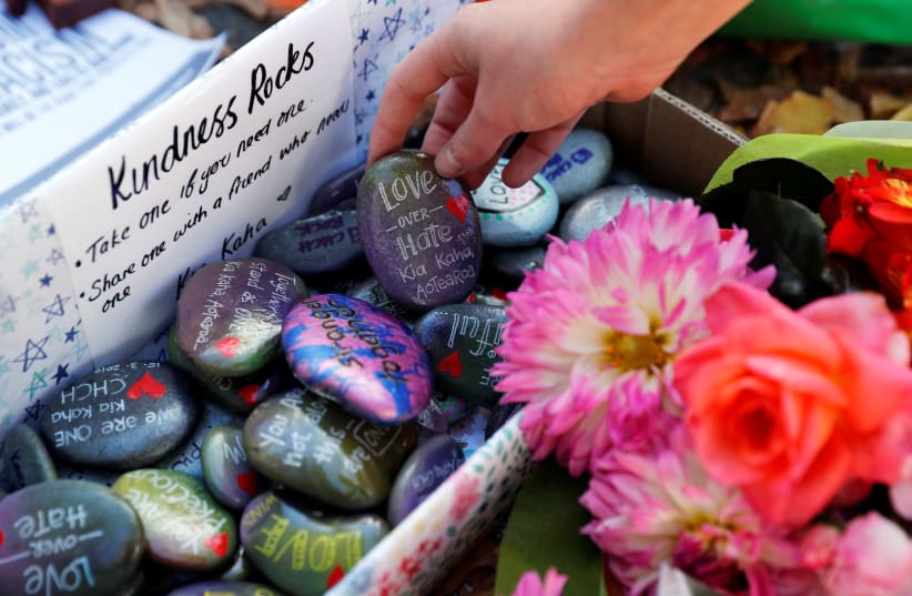 Pebbles with messages are seen at a memorial site for victims of Friday's shooting, in front of Christchurch Botanic Gardens in Christchurch, New Zealand March 19, 2019.  (photo credit: JORGE SILVA / REUTERS)