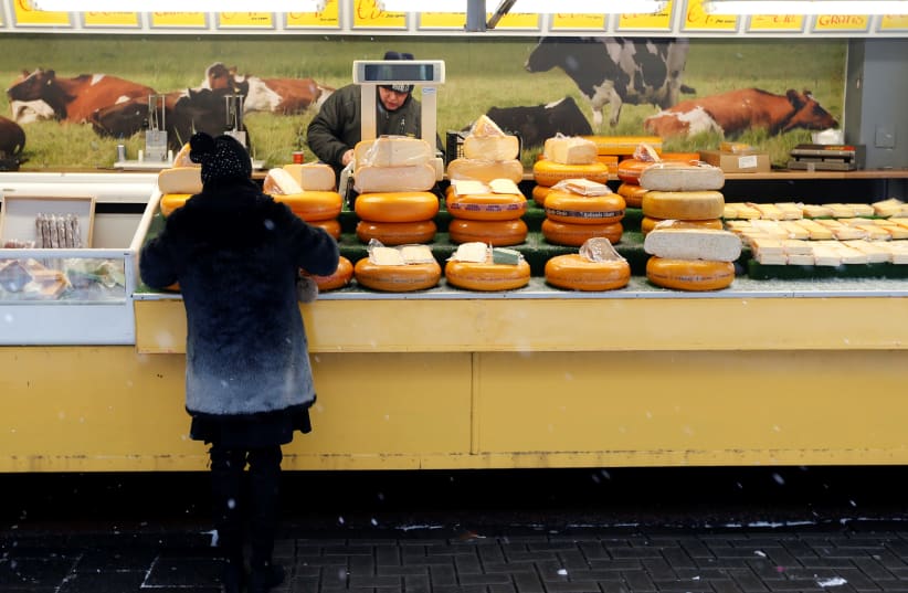 A vendor sells cheese during a weekly market in Volendam near Amsterdam (photo credit: FRANCOIS LENOIR / REUTERS)
