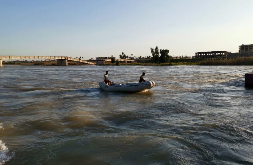Iraqi rescuers search for survivors over the site where an overloaded ferry sank in the Tigris river (photo credit: STRINGER/ REUTERS)