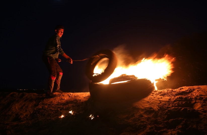 Palestinian protesters take part in a night demonstration near the fence along the border with Israel, in Rafah in the southern Gaza Strip, on March 19, 2019 (photo credit: ABED RAHIM KHATIB/NURPHOTO VIA AFP)