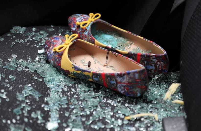 Shattered glass covers shoes left on the seat of a car that was damaged after a rocket hit a house north of Tel Aviv, Israel March 25, 2019 (photo credit: REUTERS/AMMAR AWAD)