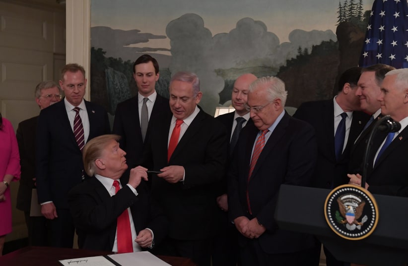 President Donald Trump signs a document acknowledging Israel's sovereignty over the Golan Heights, on March 25, 2019 as Prime Minister Benjamin Netanyahu looks on. (photo credit: AMOS BEN-GERSHOM/GPO)