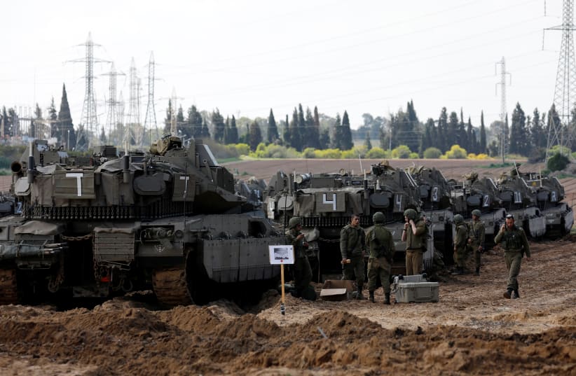 Israeli soldiers chat next to armored personnel carrier's (APC) near the border with Gaza, in southern Israel March 26, 2019 (photo credit: AMIR COHEN/REUTERS)