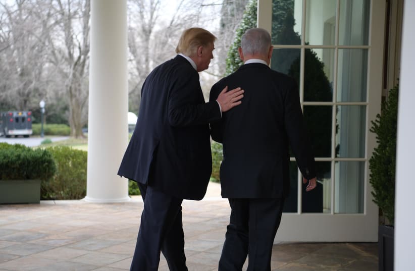 U.S. President Donald Trump (L) puts a hand on the back of Prime Minister Benjamin Netanyahu (R), March 25th, 2019 (photo credit: AMOS BEN-GERSHOM/GPO)