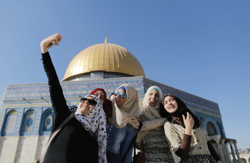 MUSLIM WOMEN pose for a selfie in front of the Dome of the Rock, Ammar Awad, 2015. (photo credit: REUTERS)
