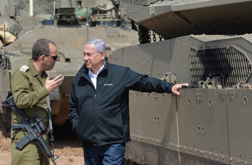 Prime Minister Benjamin Netanyahu receives a briefing from the commander of the 162nd Division during a patrol near the Gaza Strip on March 28, 2019 (photo credit: KOBI GIDEON/GPO)