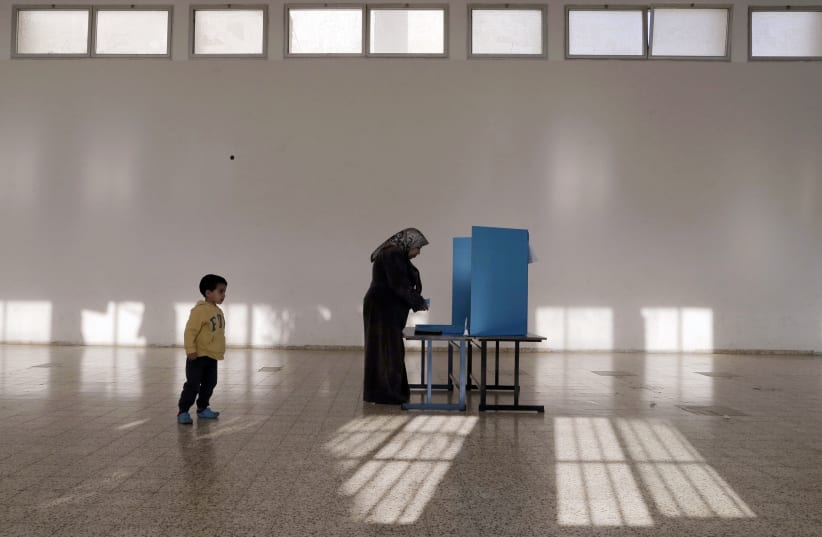 An Israeli Arab stands behind a voting booth before casting her ballot at a polling station in the northern town of Umm el-Fahm March 17, 2015 (photo credit: AMMAR AWAD/REUTERS)