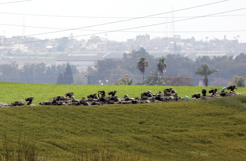 IDF ARMORED MILITARY vehicles are seen against the skyline of Gaza on Tuesday. Has a major conflict been deflected or merely delayed? (photo credit: REUTERS/AMIR COHEN)