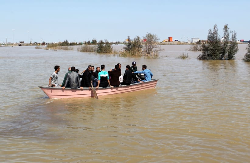 People are seen on a boat after a flooding in Golestan province, Iran, March 24, 2019. Picture taken March 24, 2019. (photo credit: TASNIM NEWS AGENCY/HANDOUT VIA REUTERS)