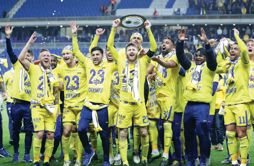 MACCABI TEL AVIV players celebrate on the pitch after clinching the Israel Premier League championship on Saturday night with a 1-0 victory over Maccabi Haifa (photo credit: DANNY MAROM)