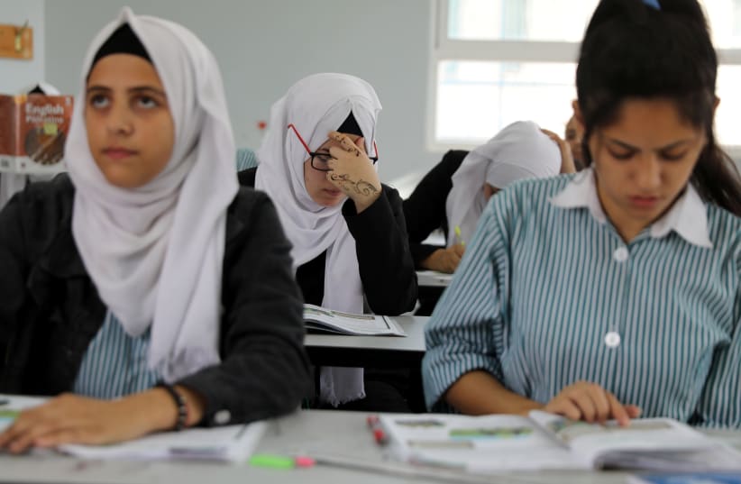 Palestinian schoolchildren take part in a lesson at a school run by UNRWA  (photo credit: AMMAR AWAD / REUTERS)
