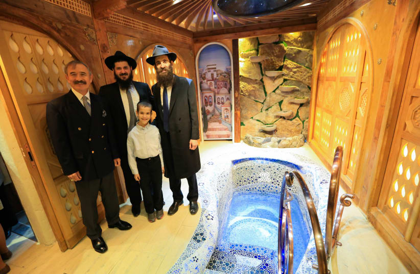 Rabbi Osher Litzman and close ones stand beside the new $850,000 mikvah in South Korea, 2019. (photo credit: CHABAD OF SOUTH KOREA)