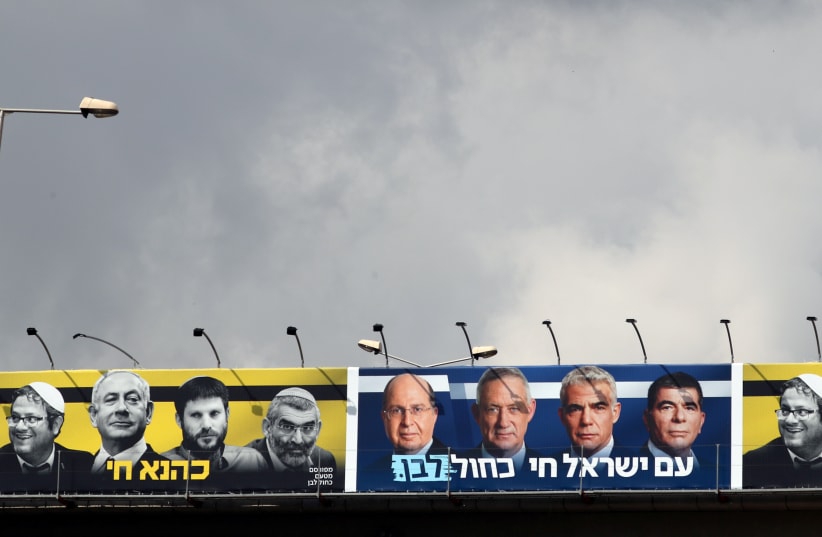 A Blue and White campaign billboard that contrasted Prime Minister Benjamin Netanyahu and his far-Right allies with party leader Benny Gantz and his party members offering the caption "The Nation of Israel Lives."  (photo credit: AMMAR AWAD / REUTERS)