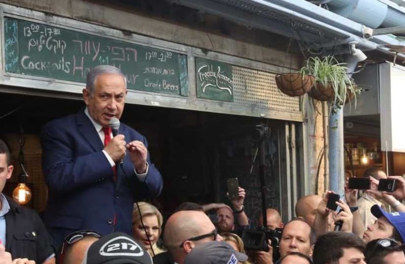 Prime Minister Benjamin Netanyahu surrounded by supporters at the Mahane Yehuda marketplace in Jerusalem April 8, 2019 (photo credit: MARC ISRAEL SELLEM)