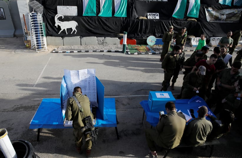 A general view shows Israeli soldiers voting at a mobile voting booth, two days before polling stations open in the rest of Israel, at a military post outside the northern Gaza Strip, in southern Israel April 7, 2019 (photo credit: AMIR COHEN/REUTERS)