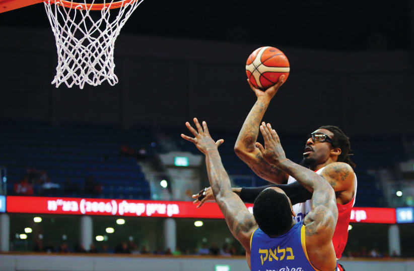 HAPOEL JERUSALEM’S Amar’e Stoudemire shoots over Maccabi Tel Aviv’s Tarik Black for two of his 22 points in the Reds’ 98-92 home overtime victory last night in BSL action (photo credit: UDI ZITIAT)