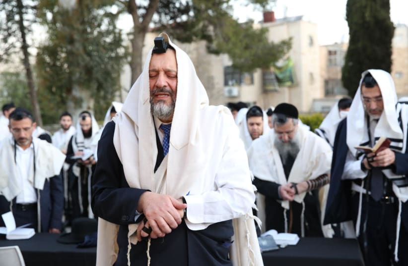 Shas leader Arye Deri prays at the grave of Rabbi Ovadia Yosef on the morning of elections (photo credit: YAAKOV COHEN/MAARIV)