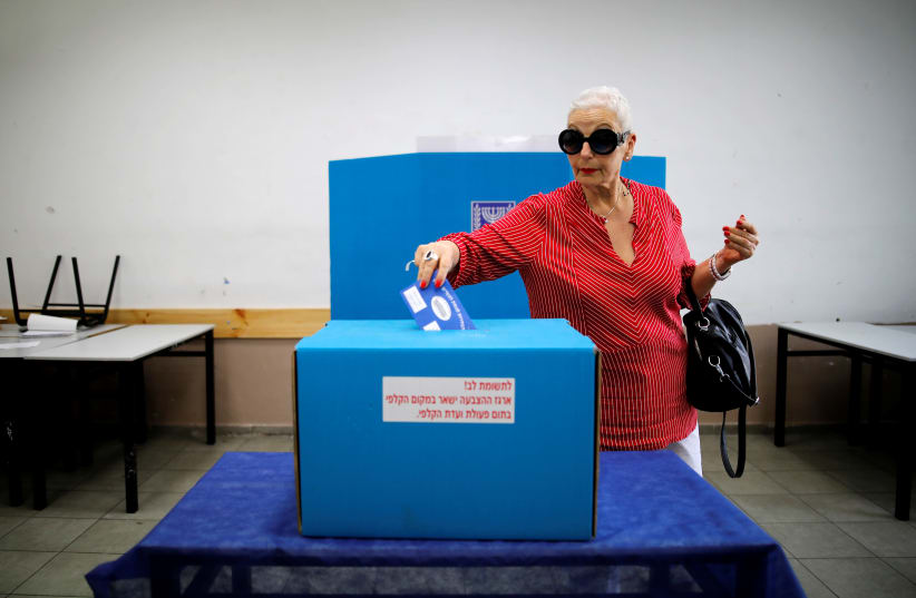 A woman casts her ballot as Israelis vote in a parliamentary election, at a polling station in Tel Aviv, Israel April 9, 2019 (photo credit: CORINNA KERN/REUTERS)
