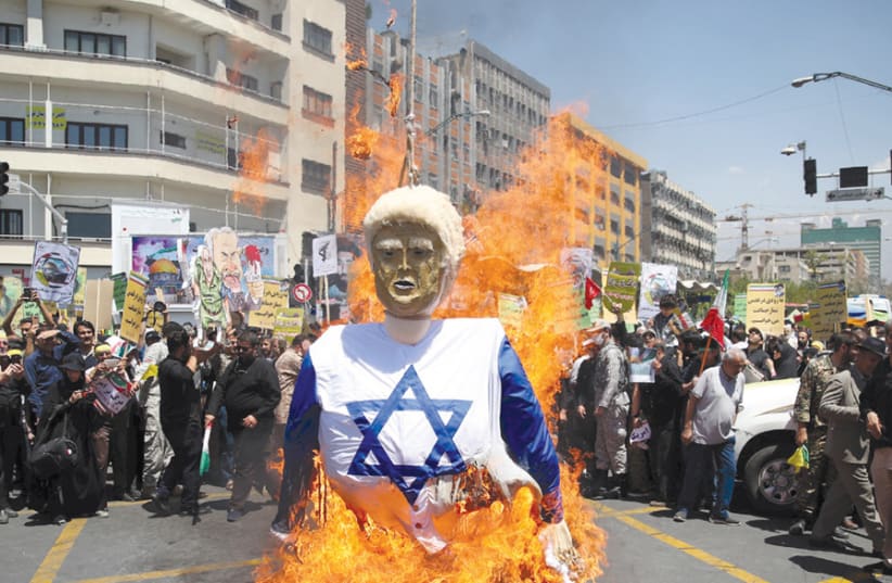 Iranian protesters burn an effigy in the likeness of US President Donald Trump dressed in an Israeli flag during a demonstration marking Jerusalem Day on June 8, 2018 (photo credit: REUTERS/TASNIM NEWS AGENCY)
