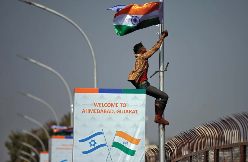 A MAN climbs a pole during Benjamin Netanyahu’s visit to India in January 2018 (photo credit: REUTERS)