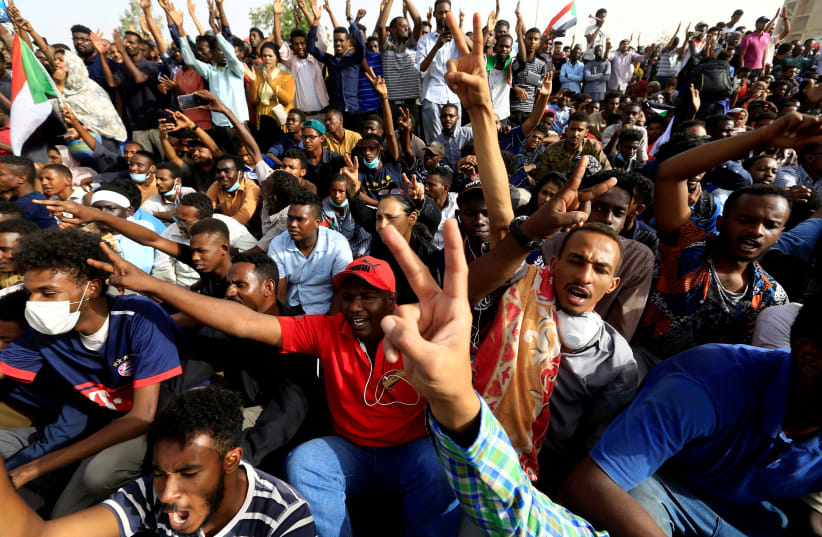 Sudanese demonstrators cheer as they attend a protest rally demanding Sudanese President Omar Al-Bashir to step down outside the Defence Ministry in Khartoum, Sudan April 11, 2019 (photo credit: STRINGER/ REUTERS)