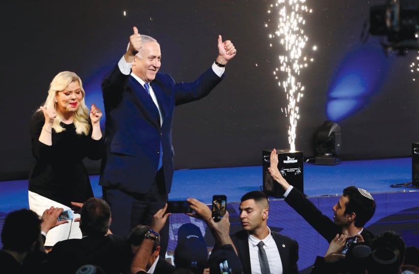 PRIME MINISTER Benjamin Netanyahu and his wife, Sara, celebrate at Likud Party headquarters in Tel Aviv late Tuesday night, April 9, 2020 (photo credit: RONEN ZVULUN/REUTERS)