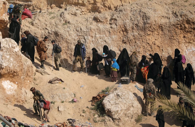WOMEN AND their families surrender in the last ISIS-held area in Syria last month (photo credit: REUTERS)