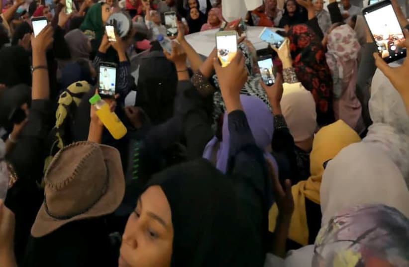 A Sudanese woman gestures during a protest demanding Sudanese President Omar Al-Bashir to step down along a bridge in Khartoum, Sudan April 8, 2019, in this still image taken from a social media video obtained on April 9, 2019 (photo credit: SOCIAL MEDIA/REUTERS)