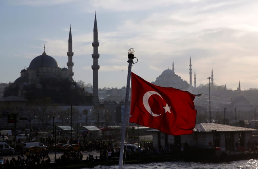 A Turkish flag, with the New and the Suleymaniye mosques in the background, flies on a passenger ferry in Istanbul, Turkey, April 11, 2019. (photo credit: MURAD SEZER/REUTERS)