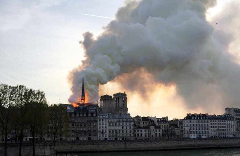 Smoke billows from the Notre Dame Cathedral after a fire broke out, in Paris, France, April 15, 2019 (photo credit: REUTERS/JULIE CARRIAT)
