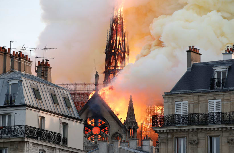 Smoke billows as fire engulfs the spire of Notre Dame Cathedral in Paris, France April 15, 2019 (photo credit: REUTERS/BENOIT TESSIER)