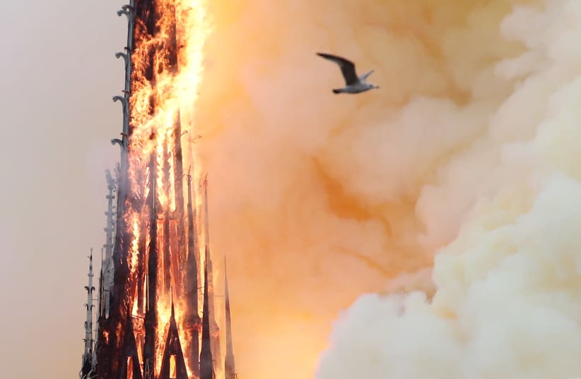 Smoke billows as fire engulfs the spire of Notre Dame Cathedral in Paris, France April 15, 2019.  (photo credit: BENOIT TESSIER /REUTERS)