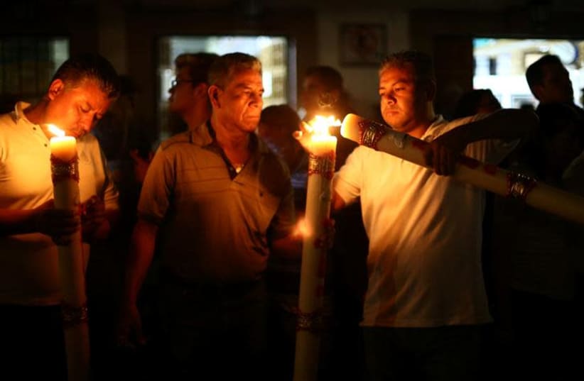 People hold candles (photo credit: REUTERS/EDGARD GARRIDO)