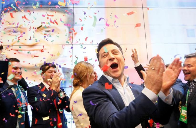 Ukrainian presidential candidate Volodymyr Zelenskiy reacts following the announcement of the first exit poll in a presidential election at his campaign headquarters in Kiev, Ukraine April 21, 2019 (photo credit: REUTERS/VALENTYN OGIRENKO)