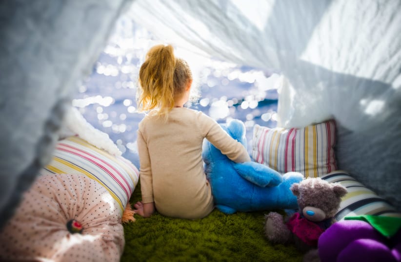 Little girl with teddy bear in camp tent (photo credit: INGIMAGE)