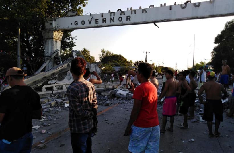 People gather near debris which collapsed and blocked a road after a quake hit Pampanga province (photo credit: REUTERS)