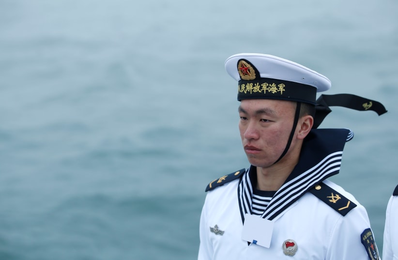 A Chinese navy personnel stands guard during a naval parade off the eastern port city of Qingdao to mark the 70th anniversary of the founding of Chinese People's Liberation Army Navy, China, April 23, 2019.  (photo credit: JASON LEE / REUTERS)