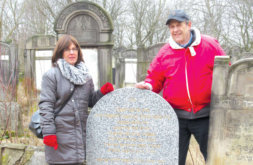 Lizzie Rubin and brother Marvin Tark connect with their roots at the grave of a relative in the Lodz cemetery in Poland (photo credit: Courtesy)