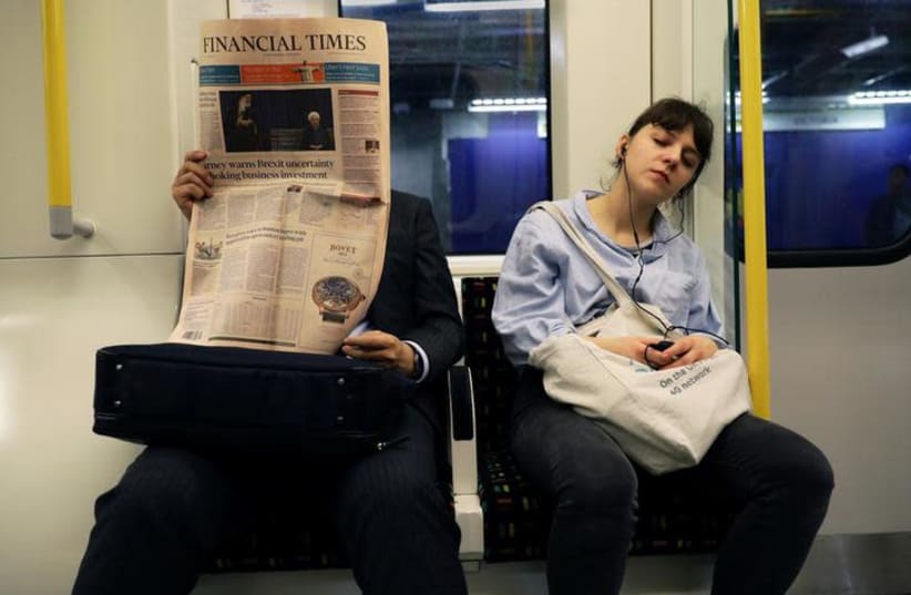 A woman sleeps on a late night train in London (photo credit: REUTERS/KEVIN COOMBS)