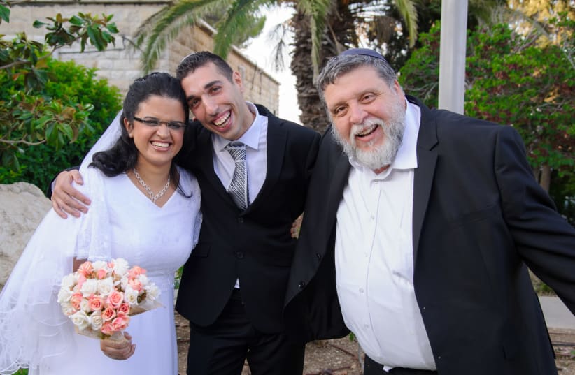 Rabbi Rafael Feuerstein beams alongside a special-needs couple on their wedding day (photo credit: SHLUMI SHALMONI)