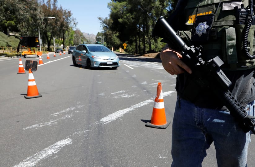 A San Diego County Sheriff’s Deputy secures the scene of a shooting incident at the Congregation Chabad synagogue in Poway, north of San Diego, California, U.S. April 27, 2019. (photo credit: JOHN GASTALDO/REUTERS)