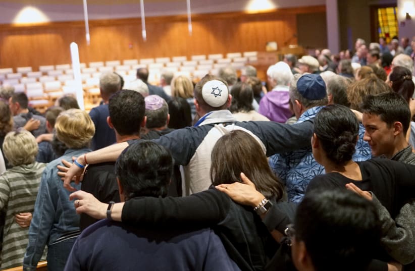 Mourners participate in a vigil for the victims of the Chabad of Poway Synagogue shooting at the Rancho Bernardo Community Presbyterian Church on April 27, 2019 in Poway, California (photo credit: SANDY HUFFAKER / AFP)