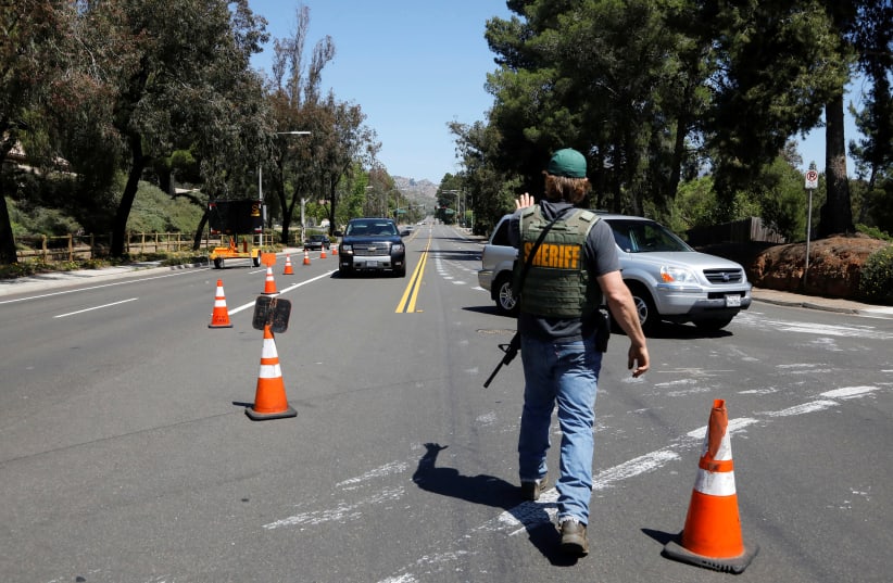 A San Diego County Sheriff’s Deputy secures the scene of a shooting incident at the Congregation Chabad synagogue in Poway, north of San Diego, California, U.S. April 27, 2019 (photo credit: JOHN GASTALDO/REUTERS)