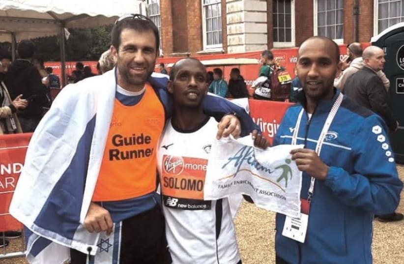 BLIND ISRAELI runner Avi Solomon (center) poses with his sighted guide Ariel Goldsmith (left) and coach Daniel Ishta (right) after completing the London Marathon on Sunday.  (photo credit: Courtesy)