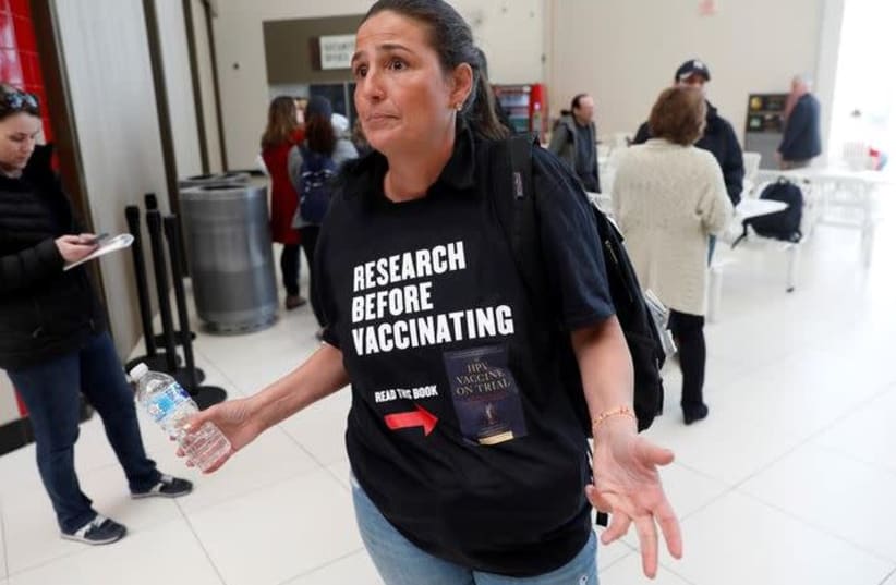  A woman opposed to childhood vaccinations takes part in a demonstration in West Nyack, N.Y., after officials in a New York City suburb banned children not vaccinated against measles from public spaces, March 28, 2019.  (photo credit: MIKE SEGAR / REUTERS)