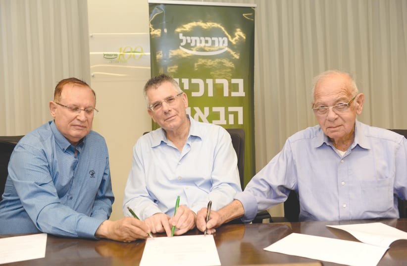 MERCANTILE CEO Shuki Burstein (center), A Computer for Every Child chairman Arie Scope (left) and the organization’s co-founder and board of directors member Ami Bergman sign the donation agreement (photo credit: MORAG BITON)